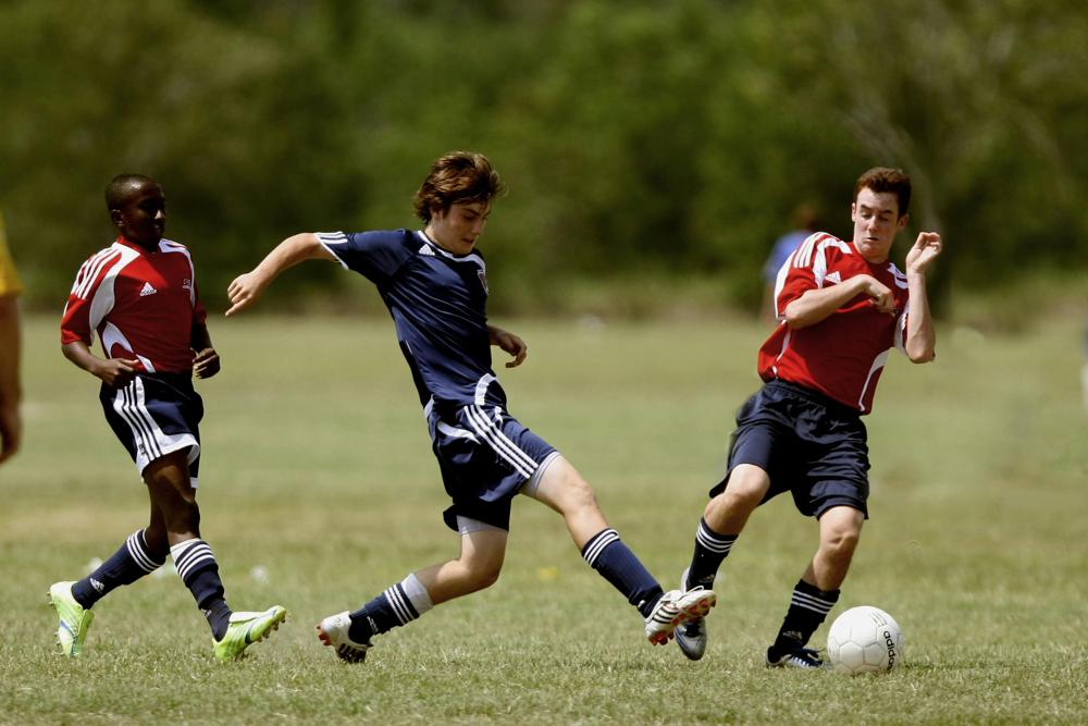 Footballers Community | Two soccer players practicing passing and ball control during training.