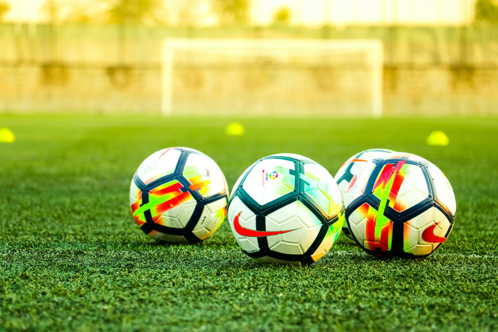Footballers Community | Footballs on the grass